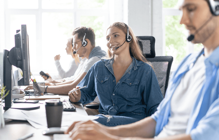 Employees with headsets sat at their desks in an office